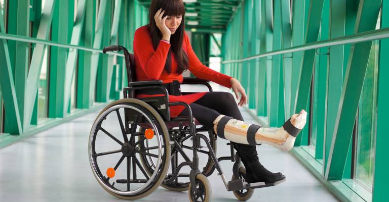 Vrouw zit in rolstoel met gebroken been